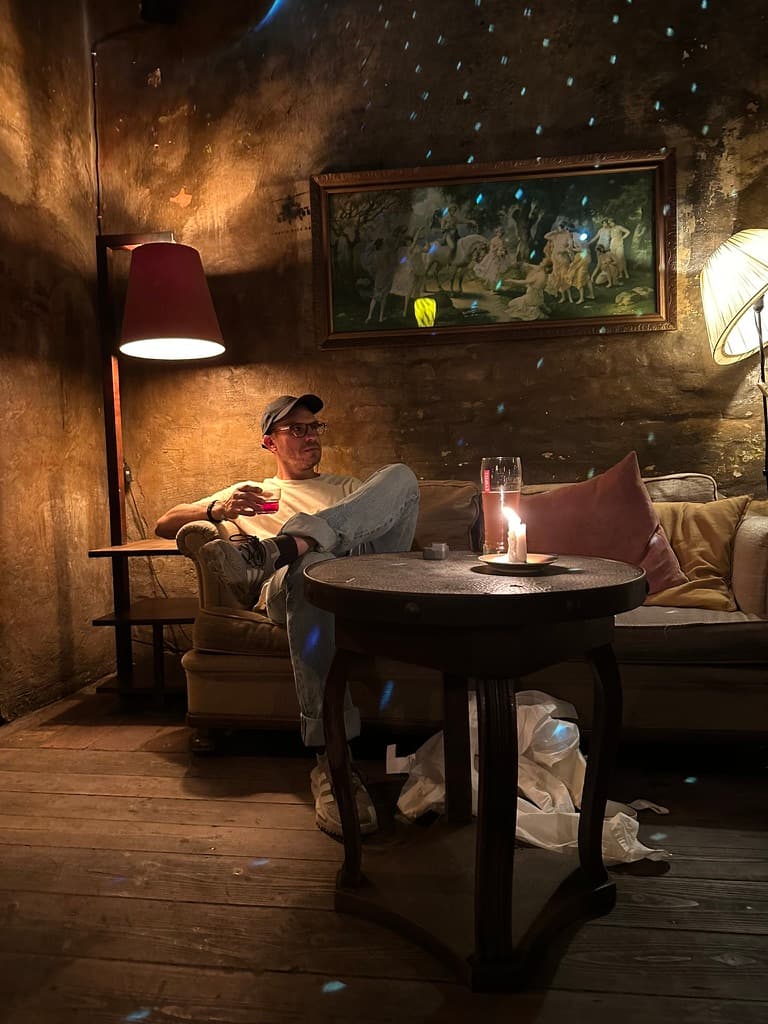 Christian sitting with a drink in a warmly lit cocktail bar