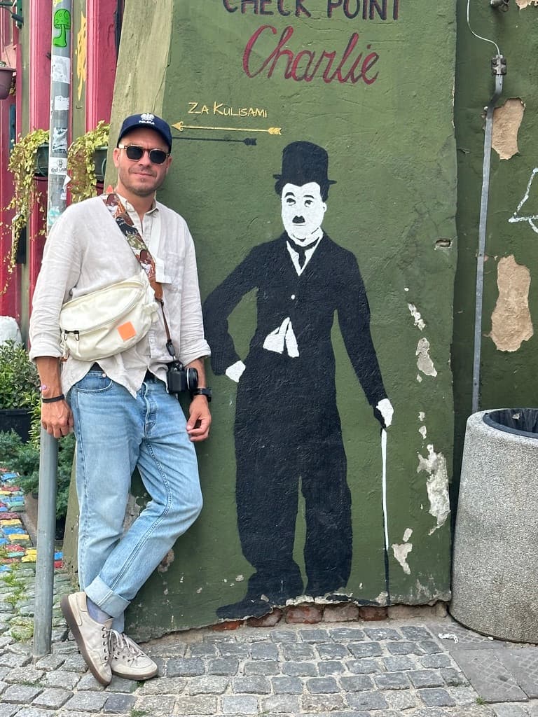 Christian with his camera beside a Charlie Chaplin mural